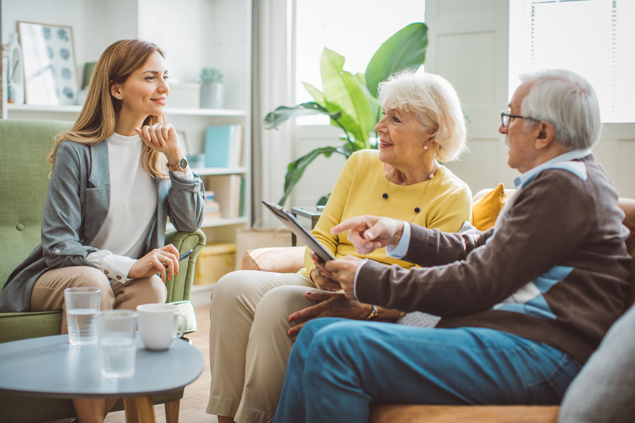 Senior couple meeting with an advisor in a bright sitting room