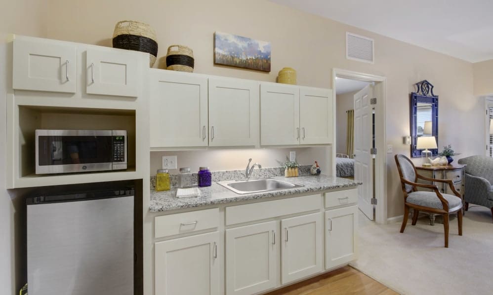 Apartment kitchenette with microwave, mini fridge and granite counters