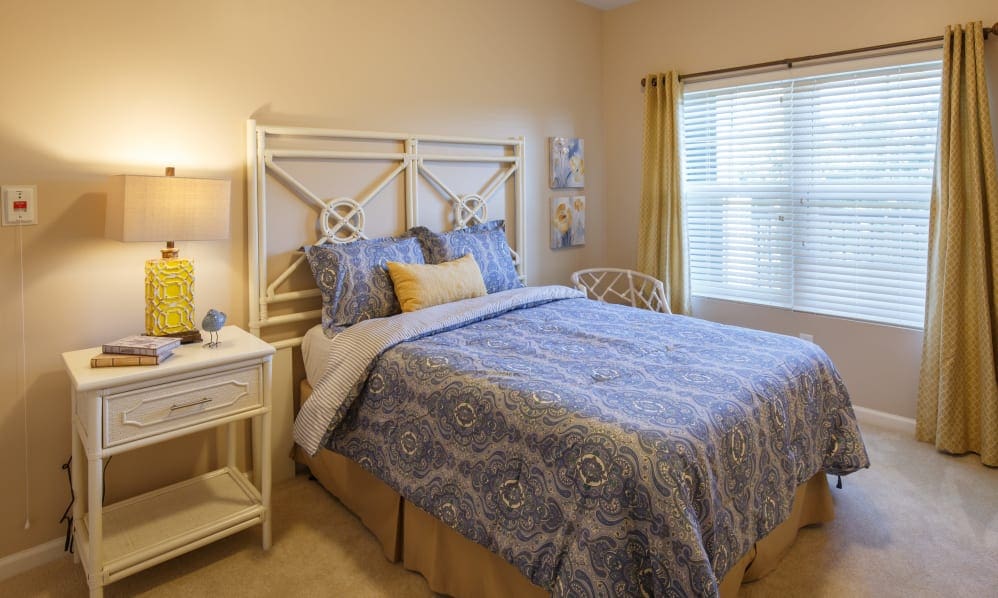 Apartment bedroom with a patterned bedspread and large window