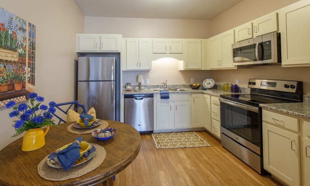 Apartment kitchen with stainless steel appliances and a dining table