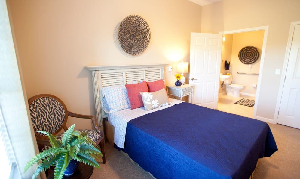 Apartment bedroom with a navy bedspread and private bathroom